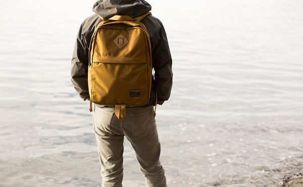Person standing in front of the ocean wearing a Paragon Guide's Edition in Coyote.